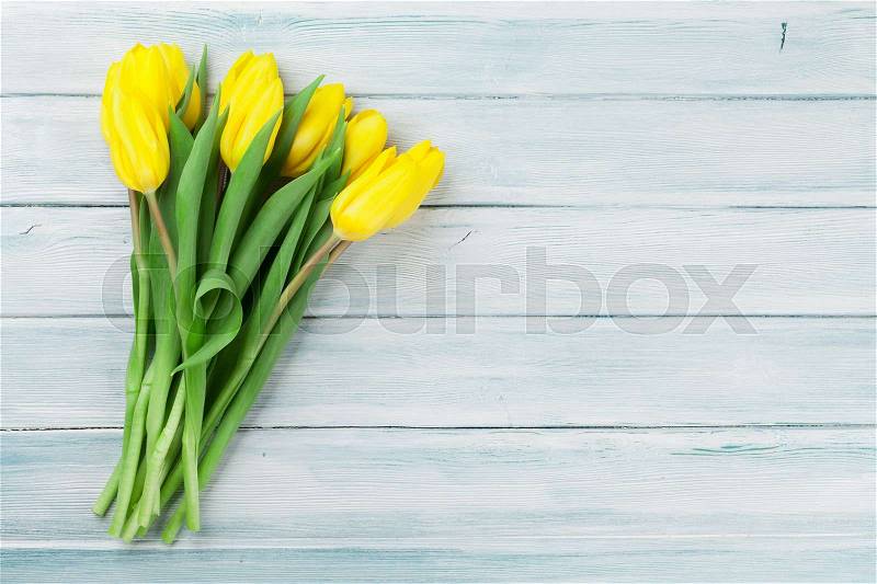Easter card wooden background with yellow tulips. With space for your greetings, stock photo
