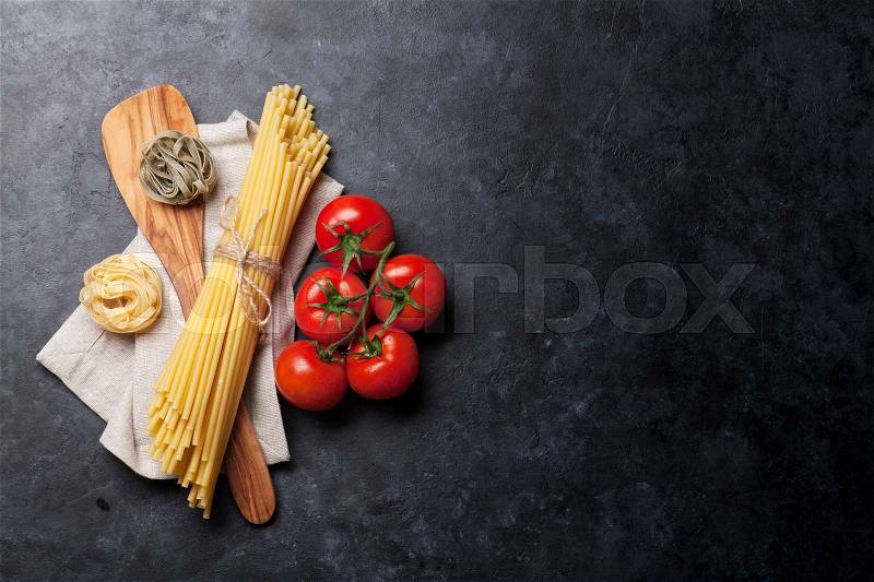 Pasta and ingredients on stone table. Top view with copy space, stock photo