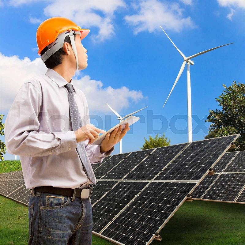 Engineers using digital tablet working and checking at industry solar power with wind turbine , stock photo