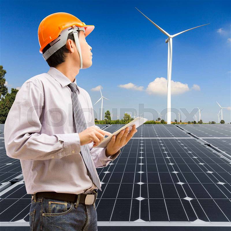 Engineers using digital tablet working and checking at industry solar power with wind turbine , stock photo