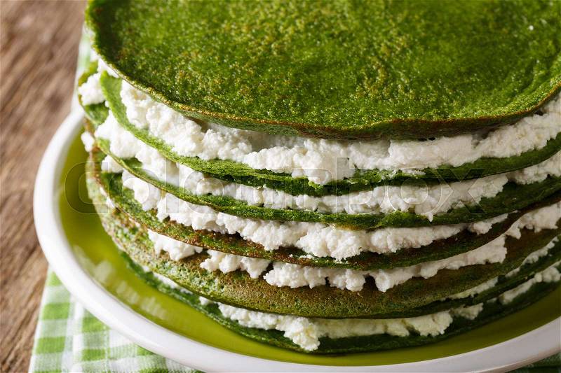 Healthy food: spinach crepes cake with cheese cream close-up on a plate. horizontal , stock photo