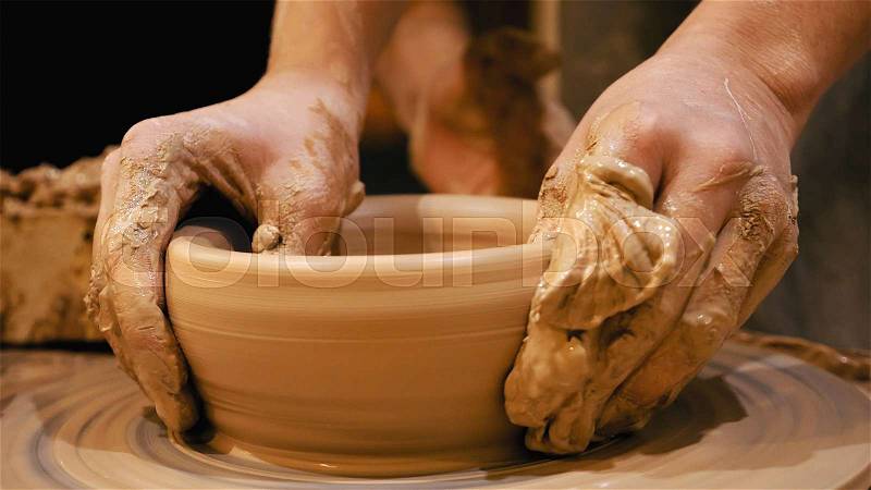 Potter is making clay pot bowl or vase ceramics porcelain on the potter\'s wheel. Creating pottery art and handicraft modelling creation, stock photo