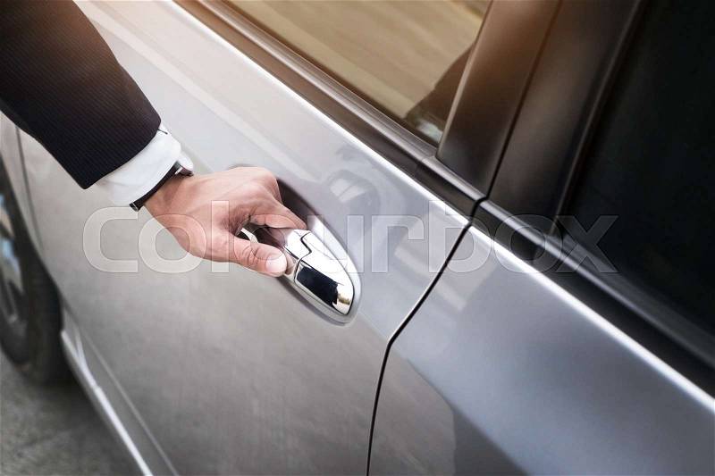 Chauffeur s hand on handle. Close-up of man in formal wear opening a passenger car door, stock photo