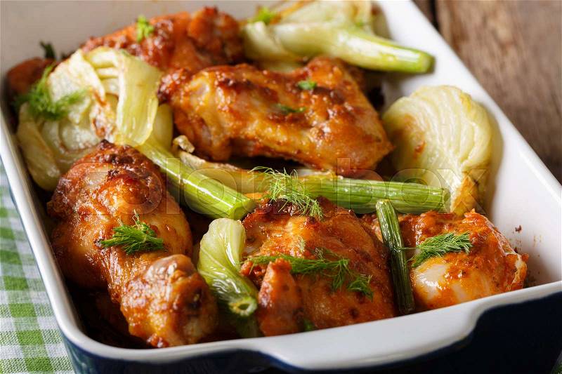 Delicious chicken baked with fresh fennel in a baking dish close-up on a table. horizontal , stock photo