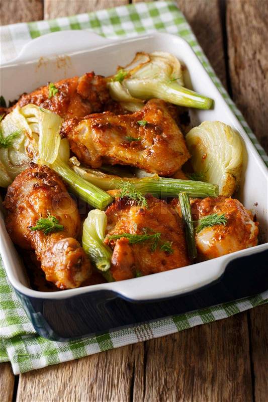 Hot chicken baked with fennel in a baking dish close-up on a table. vertical , stock photo