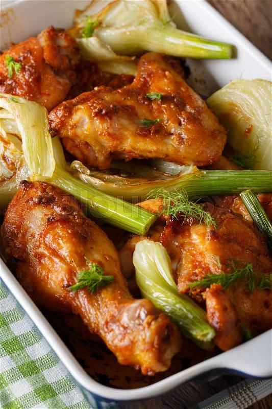 Homemade spicy chicken baked with fennel in a baking dish close-up. vertical , stock photo