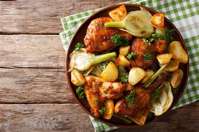 Moroccan food: pieces of chicken baked with fennel and potatoes close-up on a plate. horizontal view from above , stock photo