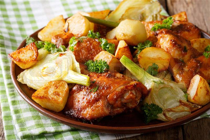 Moroccan food: pieces of chicken baked with fennel and potatoes close-up on a plate. horizontal , stock photo