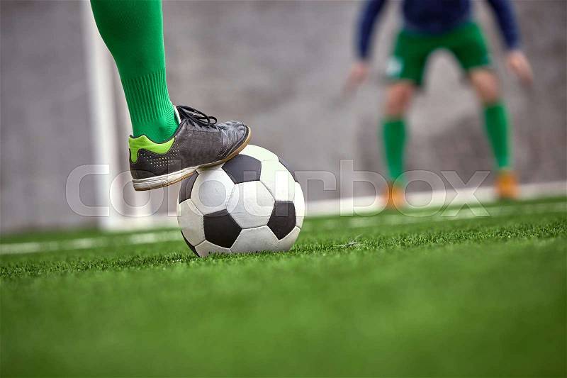 Thq leg of soccer football player training football on green grass field, stock photo