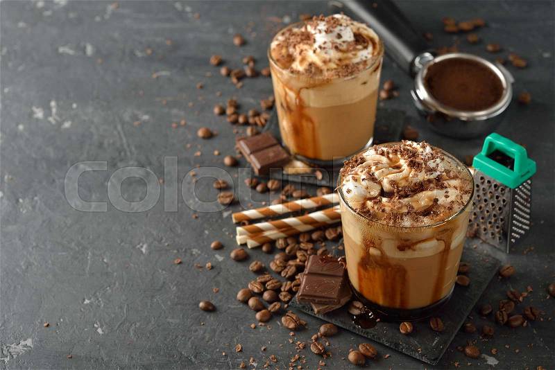 Cold frappe coffee with cream on a gray background, stock photo