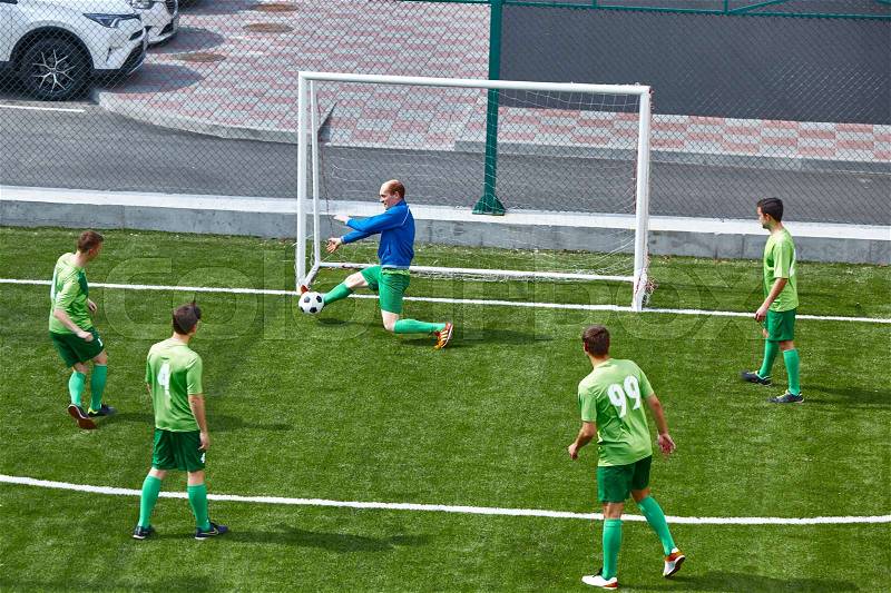 Soccer football goalkeeper making diving save on green fuild, stock photo