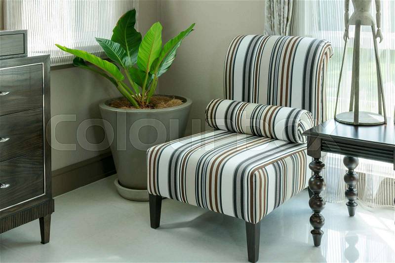 Elegant living room interior with striped pattern pillows on armchair, stock photo