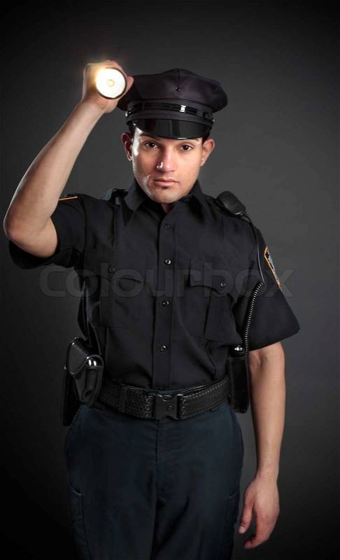 A policeman, night patrolman or security guard shining a flashlight torch to investigate or search, stock photo