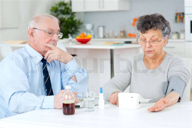 Senior couple sorting their medications for the week, stock photo
