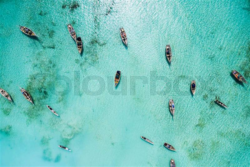 Lots of fishing boats in clear turquoise ocean near Africa, top view, stock photo