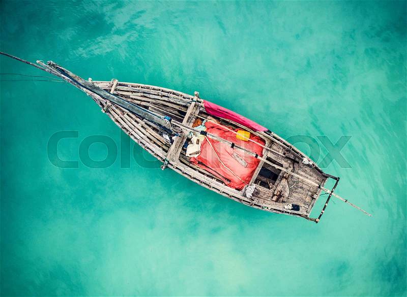 Lonely fishing boat in clean turquoise ocean, aerial photo, top view, stock photo