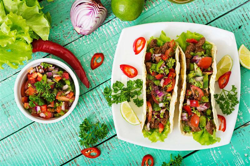 Mexican tacos with beef in tomato sauce and salsa, stock photo