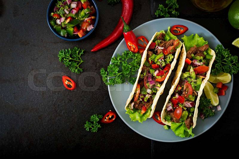 Mexican tacos with beef in tomato sauce and salsa, stock photo