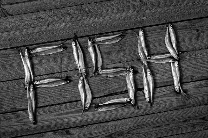The word fish from fishs on a wooden background, black and white, stock photo