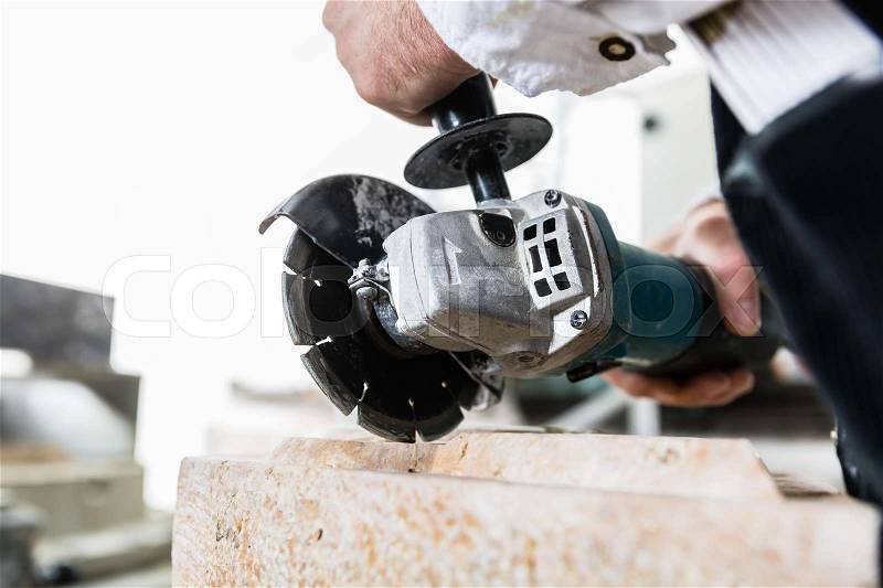 Handyman working at marble stone with disc grinder, stock photo