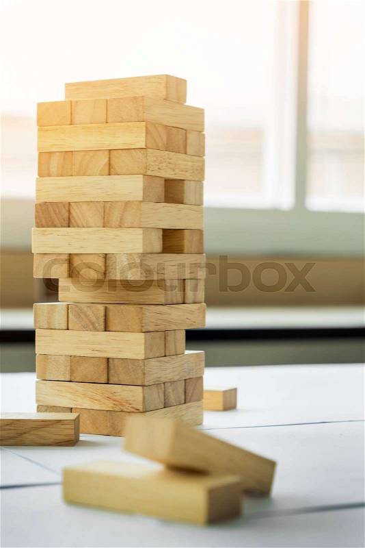 The blocks wood tower game with architectural engineer plans or blue prints compasses ,pencils and ruler on wooden table, plan and building concept, stock photo