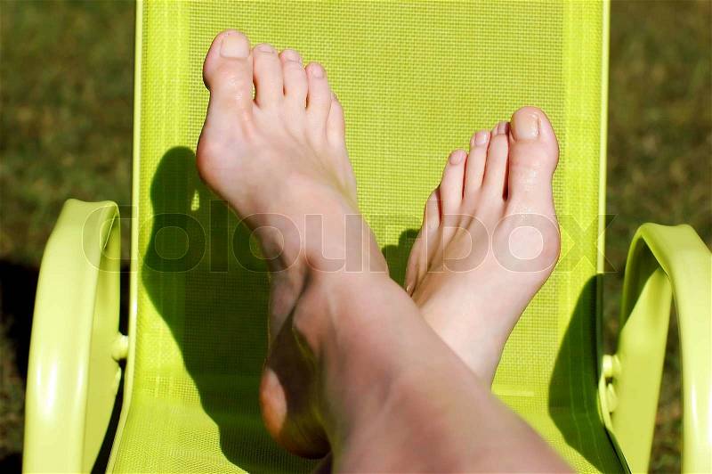 Relax - female feet on the little green chair, stock photo