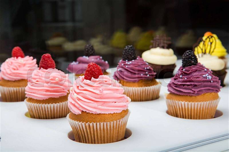 Colorful cupcakes with different Tastes. Small beautifull cakes on white table top. Popular dessert in restaurants cafes, confectioneries, stock photo