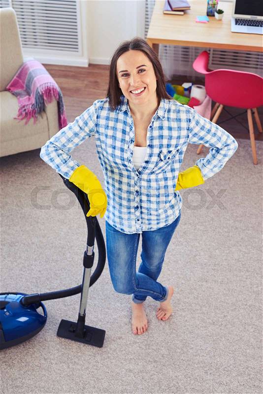 Overhead shot of good-looking housewife having finished cleaning of carpet, stock photo
