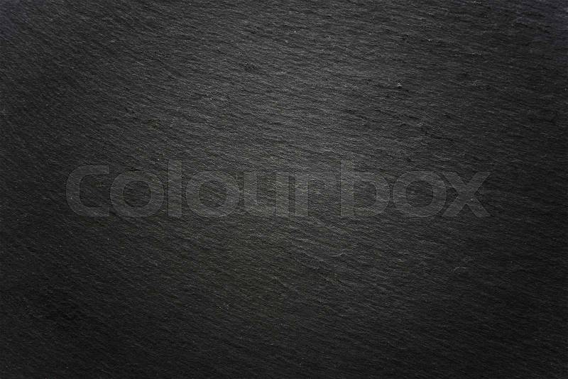 Vignetted dark gray slate surface background, stock photo