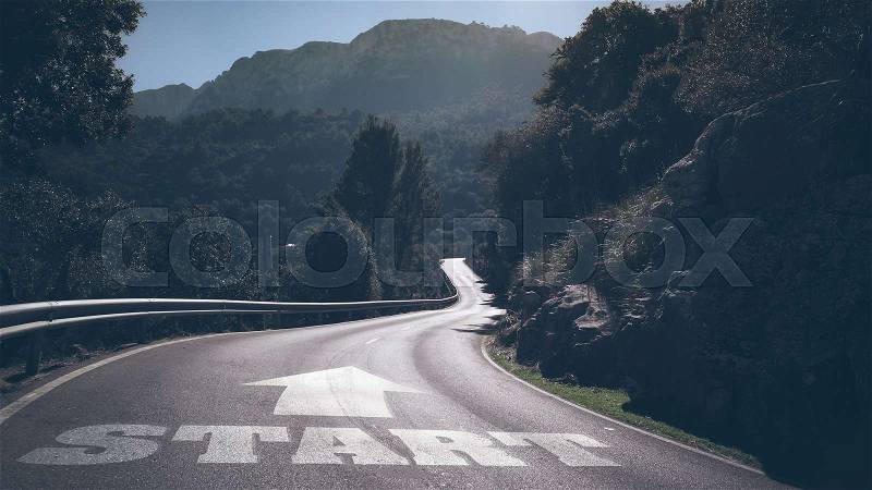 Long deserted road through mountains with word start and arrow on asphalt, stock photo
