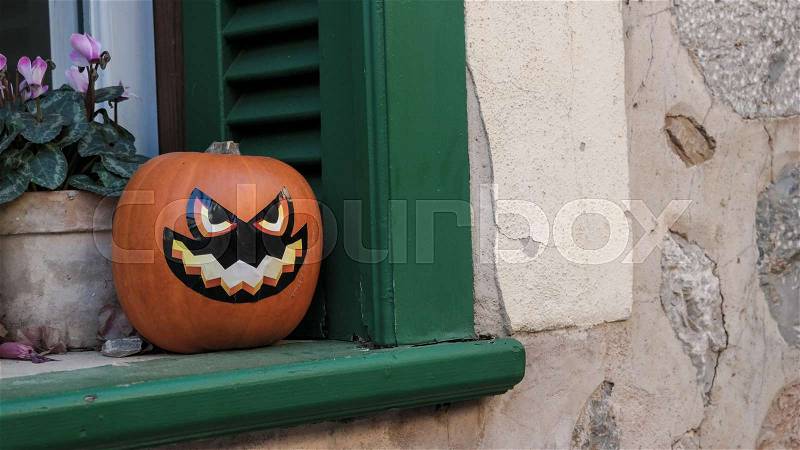 Jack O\'Lantern halloween pumpkin on green window ledge, stock photo