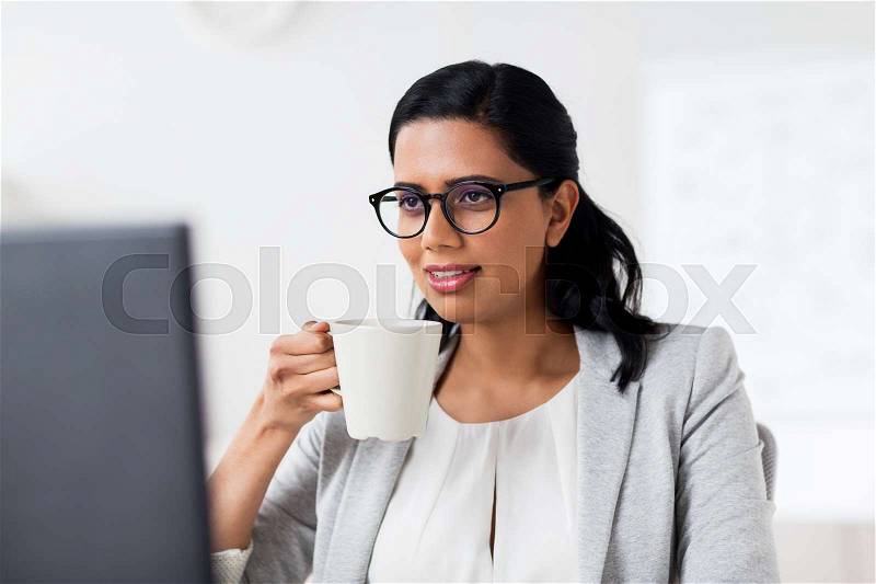 Business, people, work and technology concept - happy businesswoman with computer drinking coffee at office, stock photo