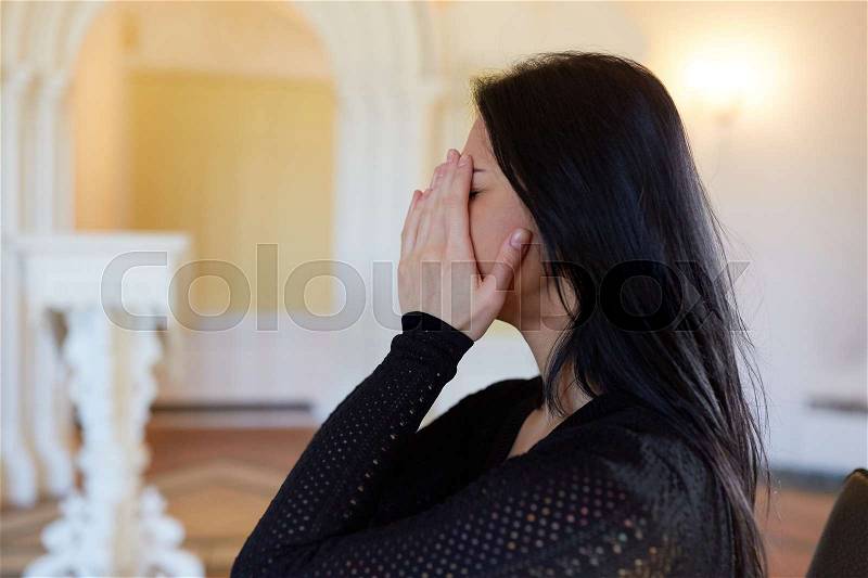 Burial, people and mourning concept - crying unhappy woman at funeral in church, stock photo