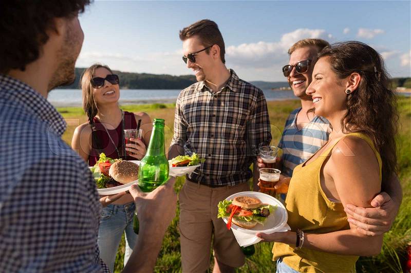 Group of friends with typical menu of summer barbecue party, burger and beer, stock photo
