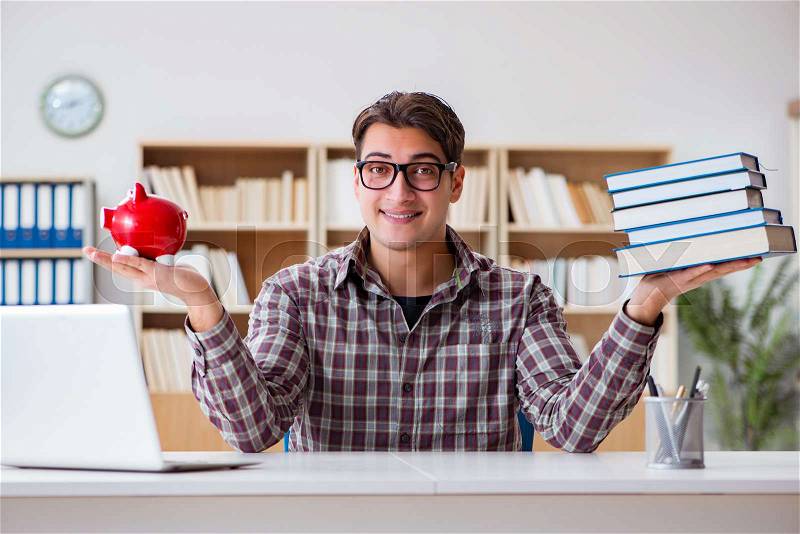 Student breaking piggybank to pay for tuition fees, stock photo