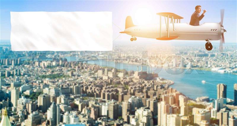 Biplane with businessman and blank banner, stock photo