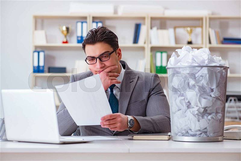 Businessman in paper recycling concept in office, stock photo