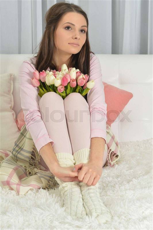 Portrait of a beautiful young woman with tulips, stock photo