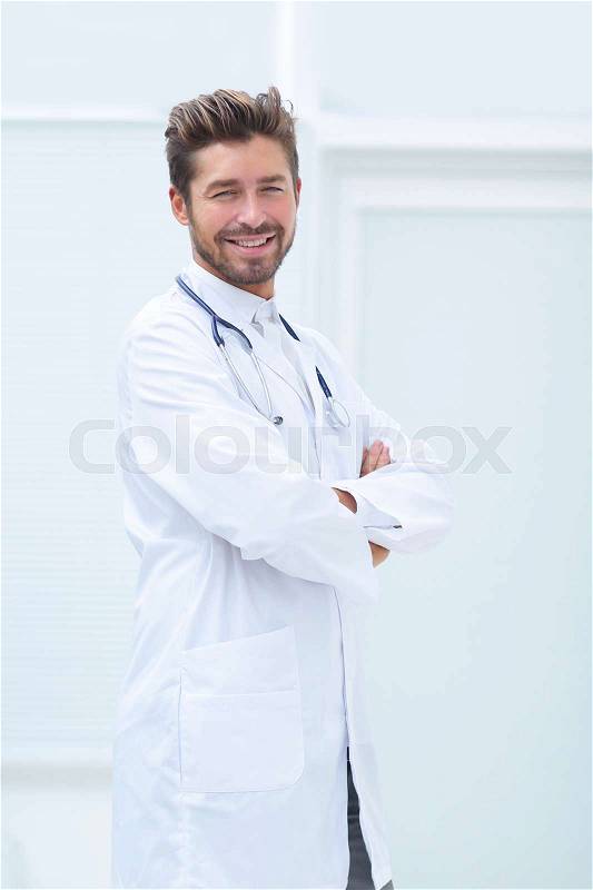 Portrait of confident male doctor with arms crossed standing, stock photo