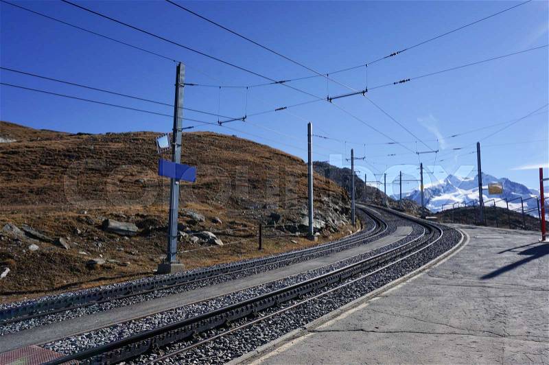Beautiful scenic train railway transportation on alp with snow mountain in daylight, Switzerland, stock photo