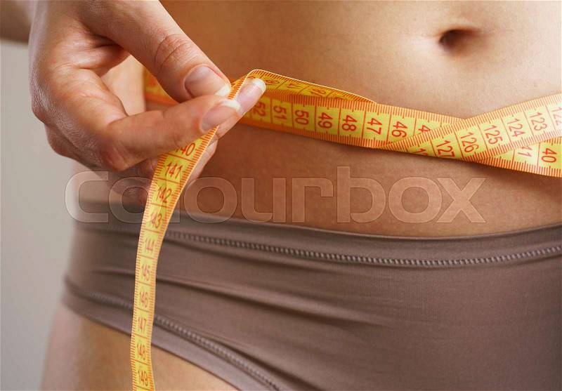 Woman measures a waist with a centimeter ribbon, stock photo