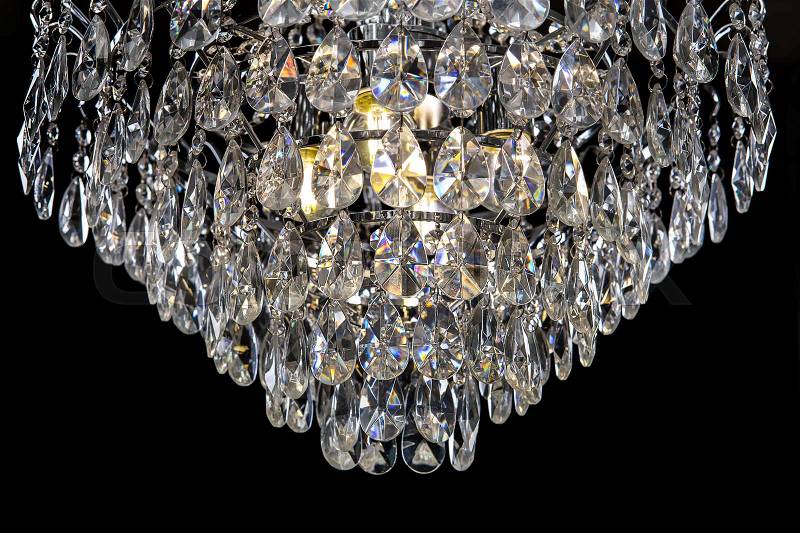 Contemporary silver chandelier isolated on black background. Crystal chandelier close-up, stock photo