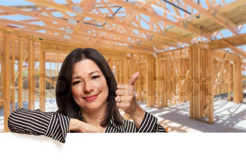 Hispanic Woman With Thumbs Up On Site Inside New Home Construction Framing, stock photo