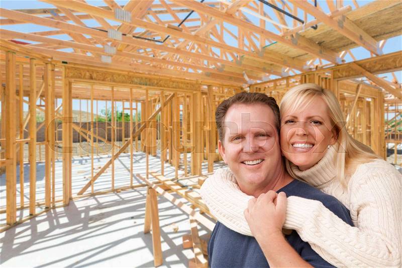Happy Excited Couple On Site Inside Their New Home Construction Framing, stock photo