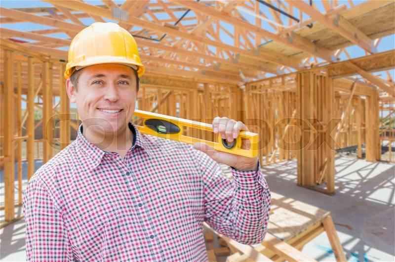 Contractor With Level On Site Inside New Home Construction Framing, stock photo