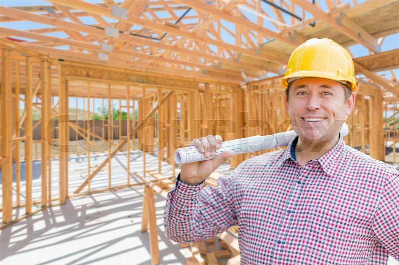 Contractor With Plans On Site Inside New Home Construction Framing, stock photo