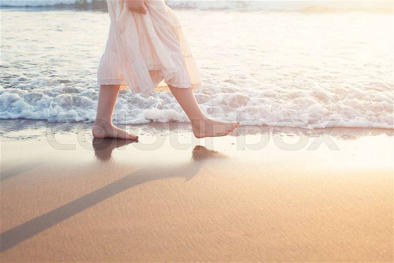 White Skirt Woman Legs Walking on Beach Vacation. Closeup of Barefoot Female Young Adult Lower Body Relaxing in Ocean Water on Summer Holiday Travel, stock photo