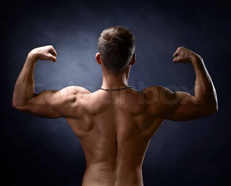 Young bodybuilder on a black background . Naked torso , stock photo