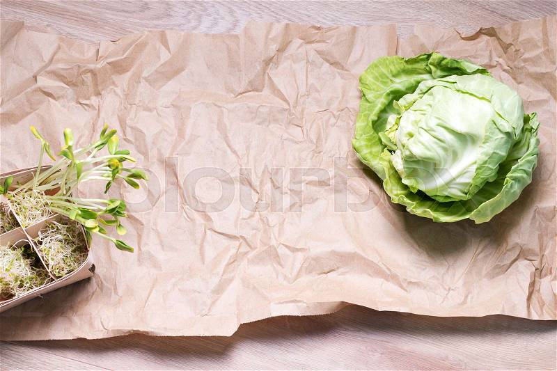 Mixed organic micro greens and cabbage on craft paper. Fresh sunflower and heap of alfalfa micro green sprouts for healthy vegan food cooking. Healthy food and diet concept. Cut microgreens, top view with copy space, stock photo