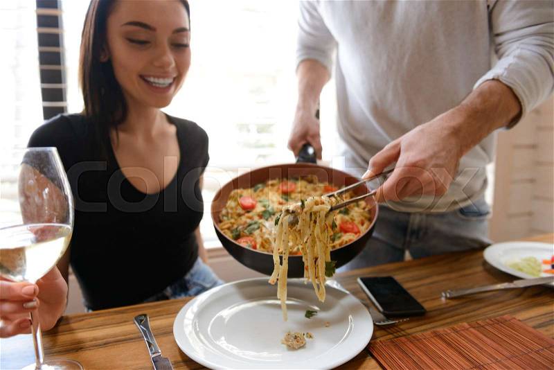 Closeup of man cooking food for his girlfriend on the kitchen at home, stock photo